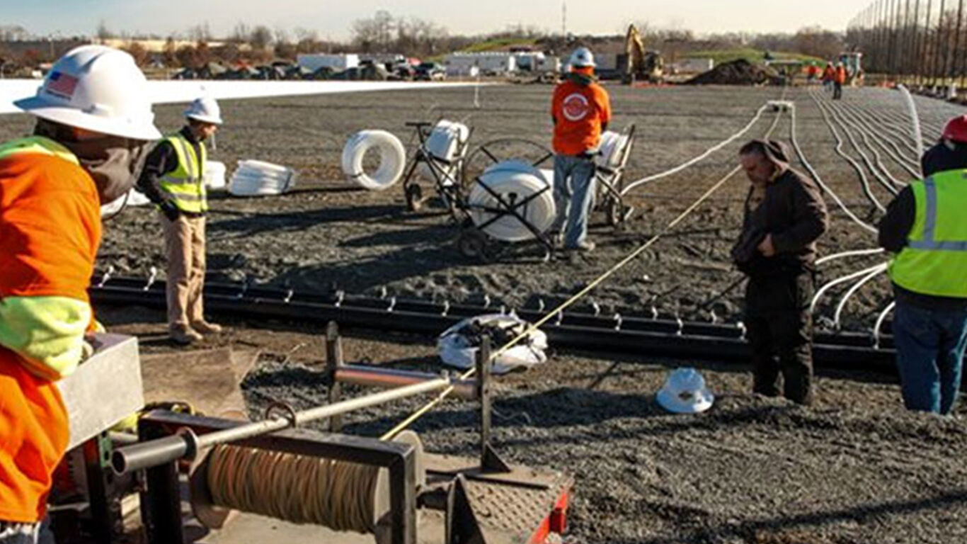 Workers installing irrigation piping onto fields